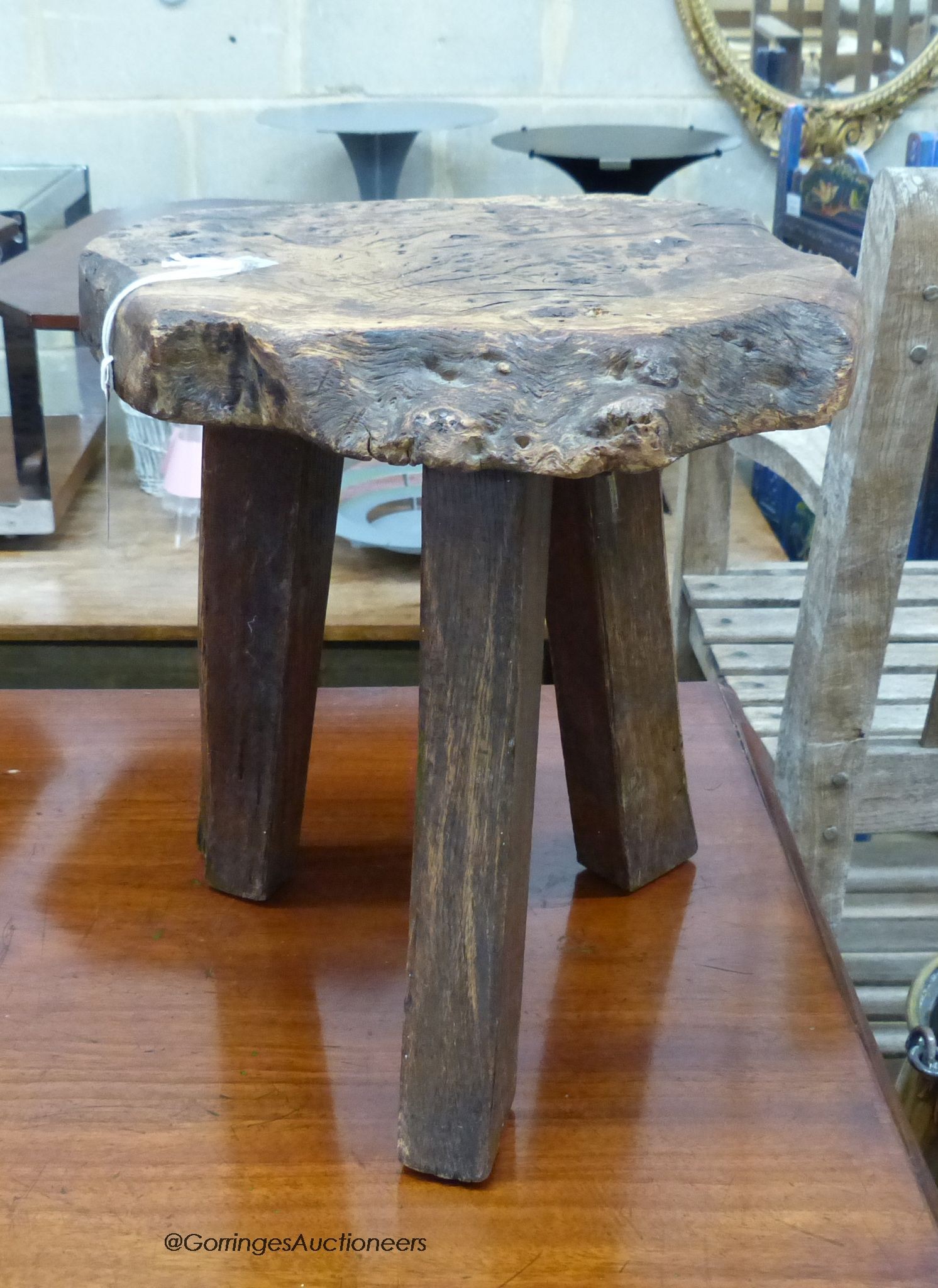 A provincial burr ash topped tripod stool, stamped Wanderwood, width 32cm, height 33cm